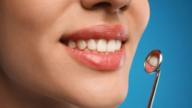 a lady is smiling after having cosmetic dentistry treatment