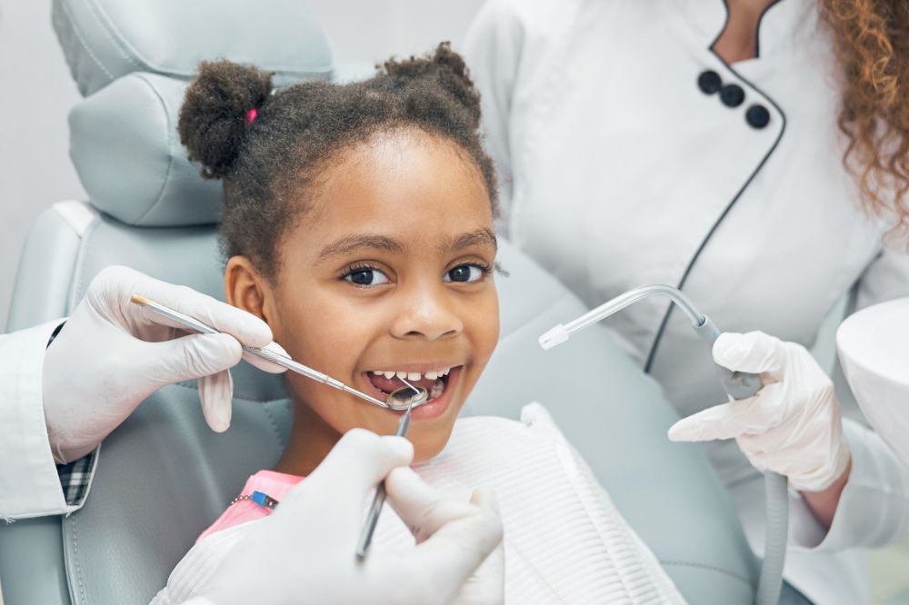 a kid is smiling while having dental treatment